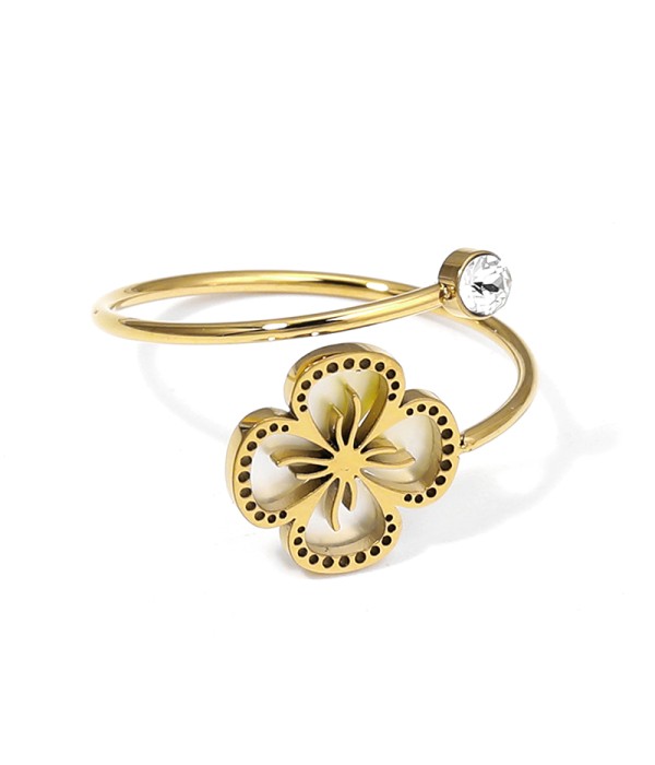 Anillo dorado con flor calada y fondo de nácar