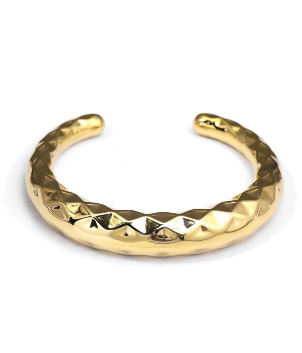 Pulsera rígida dorada con textura geométrica